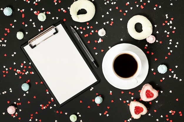 Portapapeles de maqueta con taza de café y galletas de merengue