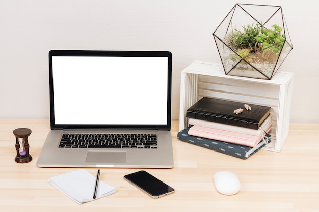 Foto gratuita portátil con cuadernos en mesa de madera