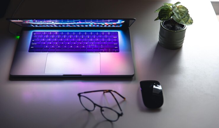Foto gratuito portátil con gráficos y estadísticas y gafas sobre la mesa.