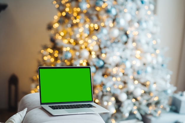 Foto gratuita portátil con pantalla verde cerca de las decoraciones de año nuevo