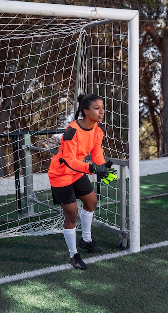 Foto gratuita portero de tiro completo con puerta de fútbol