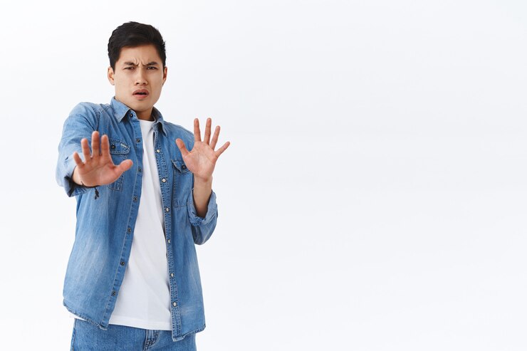 Photo Gratis portrait of disgusted young asian guy step back and defend himself, pull away from disgusting creepy thing, grimacing displeased, express dislike