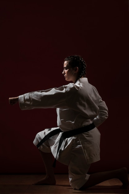 Pose de combate de mujer en uniforme de karate blanco