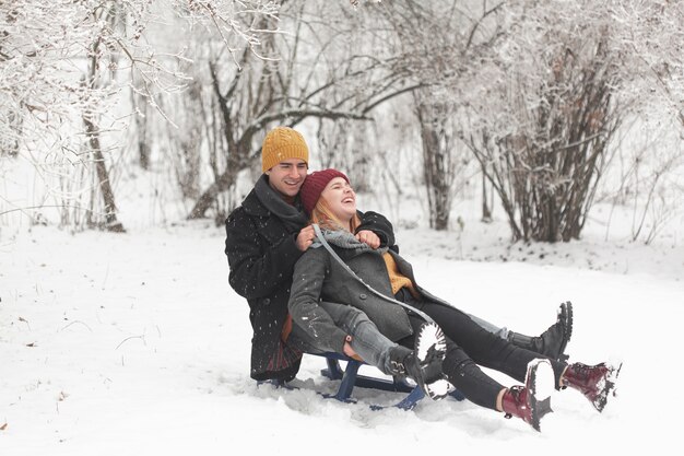 Posibilidad muy remota de la pareja sentada en un trineo en la nieve.