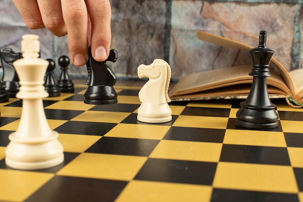 Posición de figuras de ajedrez en un tablero de ajedrez. Un jugador jugando ajedrez