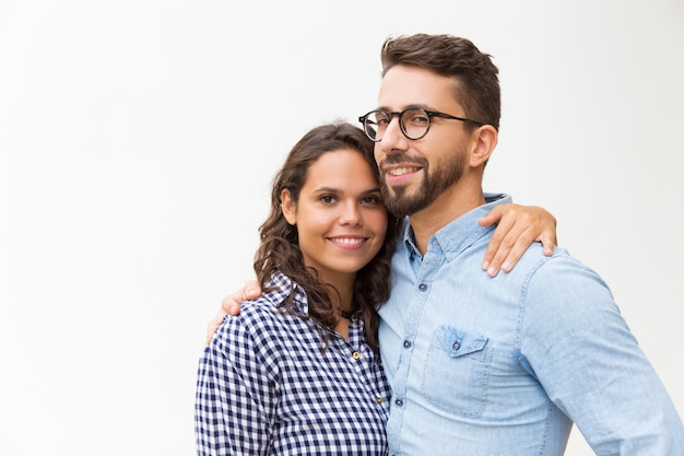 Foto gratuita positiva hermosa pareja abrazándose y mirando