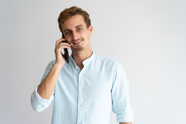 Positivo exitoso gerente masculino hablando por teléfono móvil.