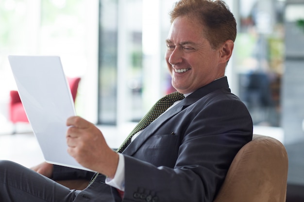 Positivo, hombre de negocios, lectura, documento, sofá