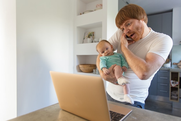 Foto gratuita positivo sorprendió a nuevo padre con bebé