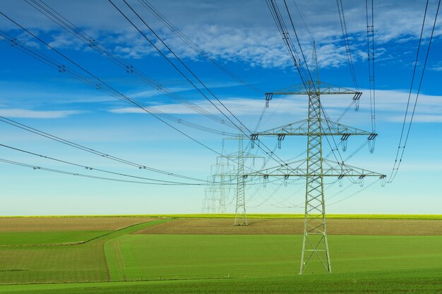 Poste eléctrico gris bajo el cielo nublado blanco y azul