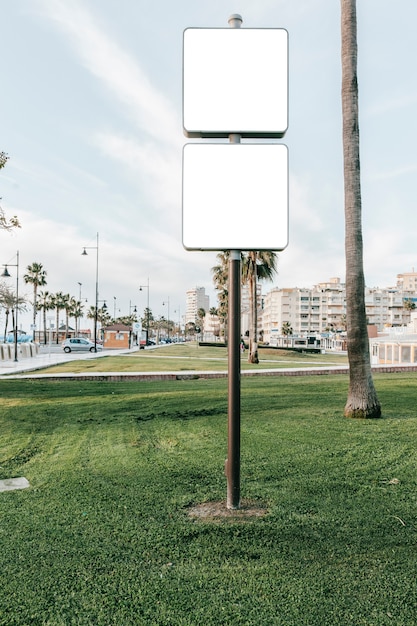 Poste indicador blanco vacío en prado verde