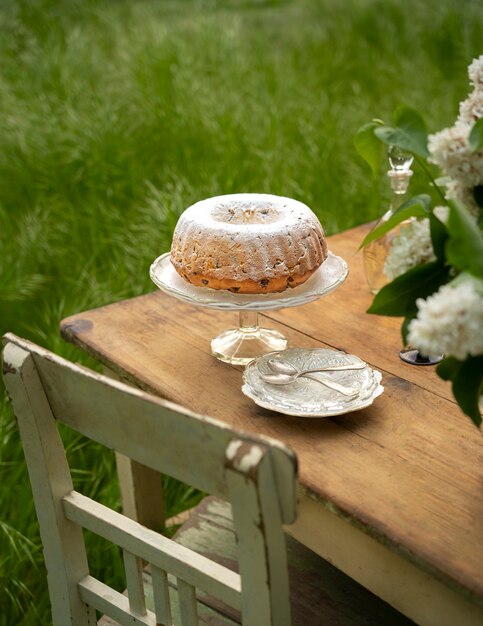 Postre de alto ángulo y flores en la mesa.