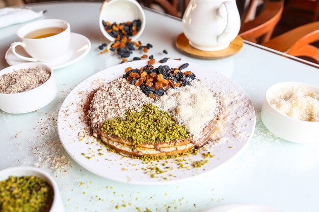 Postre con azúcar en polvo pistacho y uva seca encima