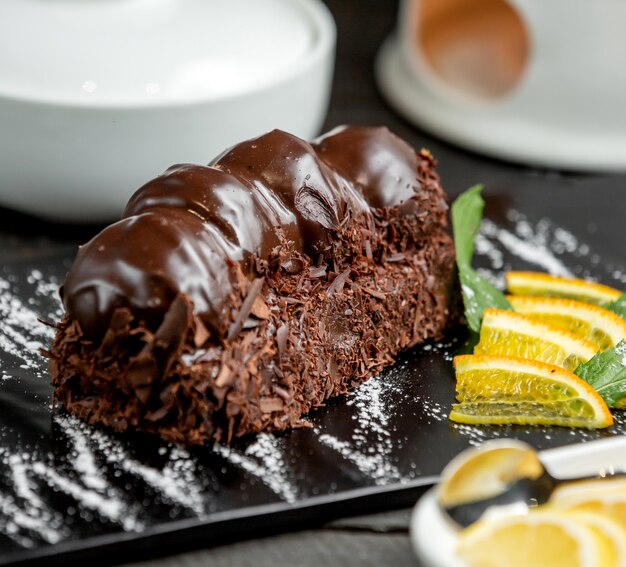 Postre de chocolate cubierto con profiteroles bañados en chocolate