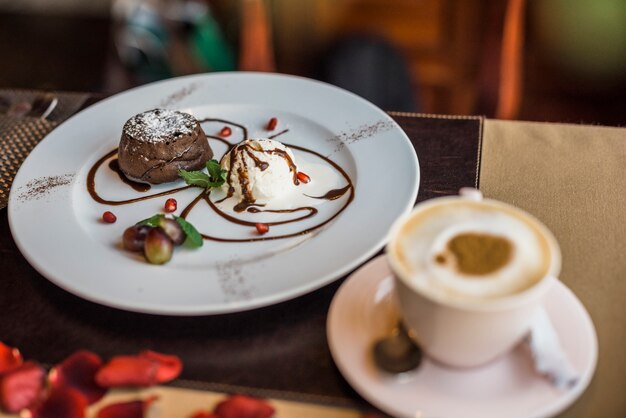 Postre de chocolate fresco delicioso y taza de bebida en restaurante