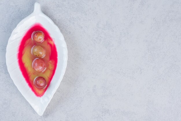 Postre dulce casero fresco, plato blanco sobre fondo gris.