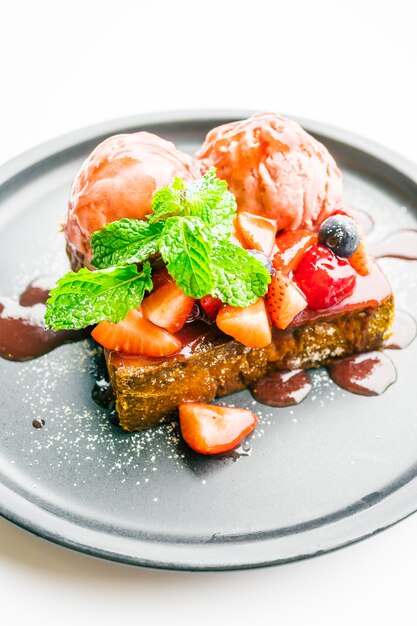 Postre dulce con tostadas de miel con fresa y mermelada.