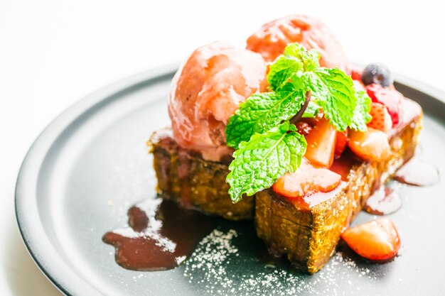 Postre dulce con tostadas de miel con fresa y mermelada.