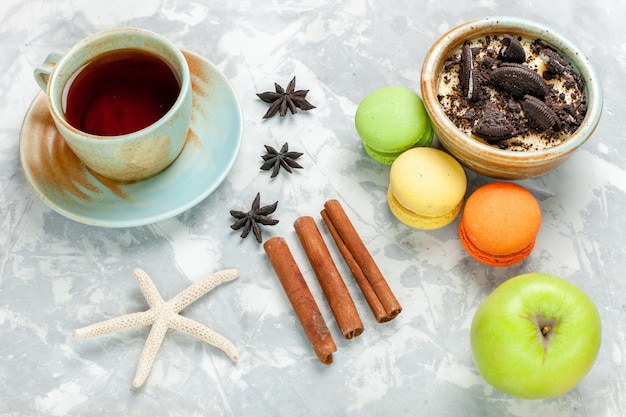 Postre de galleta de chocolate de vista superior con macarons franceses y té en la galleta de escritorio blanco claro galleta de pastel de azúcar horneado dulce