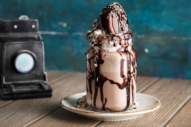 Postre helado con salsa de chocolate amargo en un plato blanco