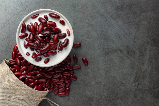 Postre de leche de coco de frijoles rojos en un tazón blanco junto a la bolsa de saco de frijoles rojos