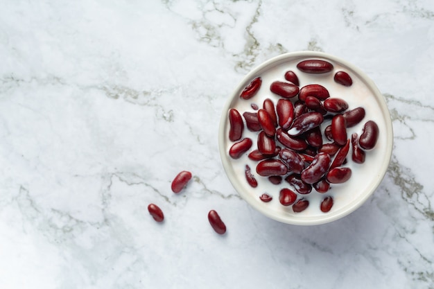 Postre de leche de coco de frijoles rojos en un tazón blanco sobre un piso de mármol blanco