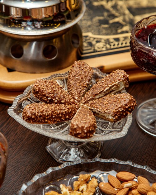 Postre de nueces y chocolate servido en plato de cristal