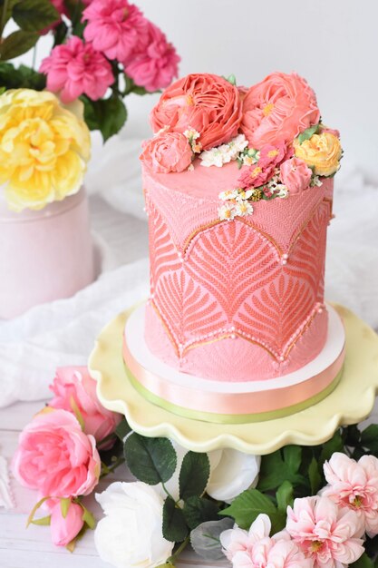 Postre de pastel de flores bellamente decorado con flores alrededor