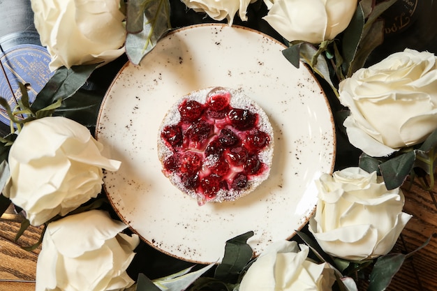 Postre en plato redondo cubierto con mermelada de frutos rojos