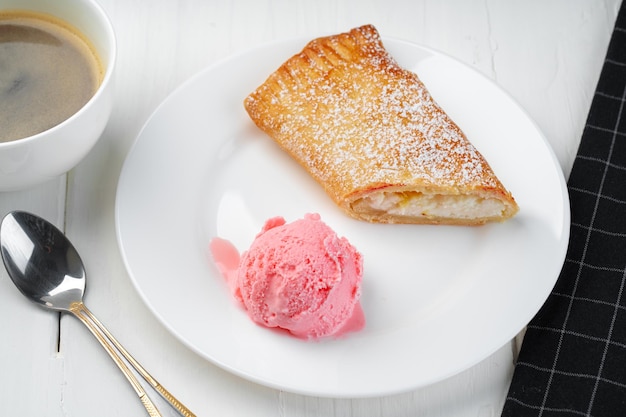 Postre shtrudel clásico con helado en la placa blanca.