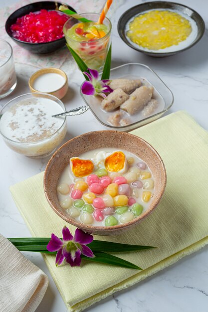 Postre tailandés llamado bolas de Bualoy en salsas con leche de coco caliente y hojas de pandan para aumentar la delicia.