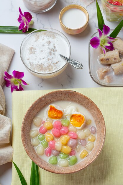 Postre tailandés llamado bolas de Bualoy en salsas con leche de coco caliente y hojas de pandan para aumentar la delicia.