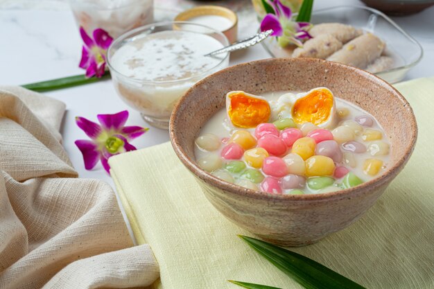 Postre tailandés llamado bolas de Bualoy en salsas con leche de coco caliente y hojas de pandan para aumentar la delicia.