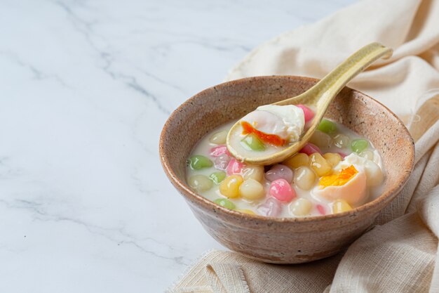 Postre tailandés llamado bolas de Bualoy en salsas con leche de coco caliente y hojas de pandan para aumentar la delicia.