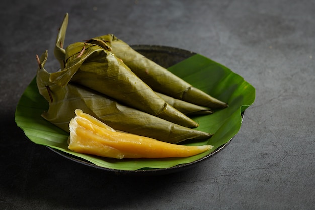 Postre tailandés. Pasteles de melón al vapor envueltos en cono de hoja de plátano