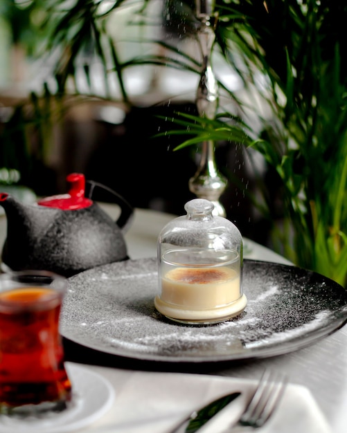 Postre en una taza de vidrio servido con té