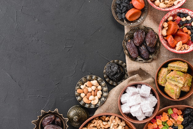 Postre tradicional de ramadan y nueces en un tazón metálico y de barro sobre fondo negro