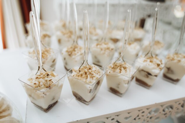 Los postres en la porción de moldes se colocan sobre la mesa de catering