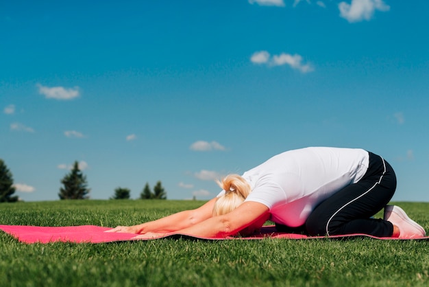 Postura de yoga de tiro completo en estera al aire libre