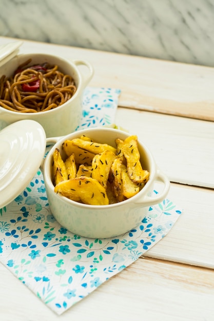 Foto gratuita pote con patatas fritas cerca de la pasta