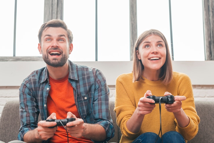 Photo Gratis potret pasangan muda tersenyum bermain video game dengan joystick