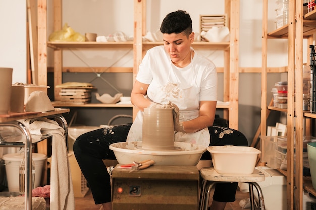 Foto gratuita potter mujer trabajando en la rueda de alfarería