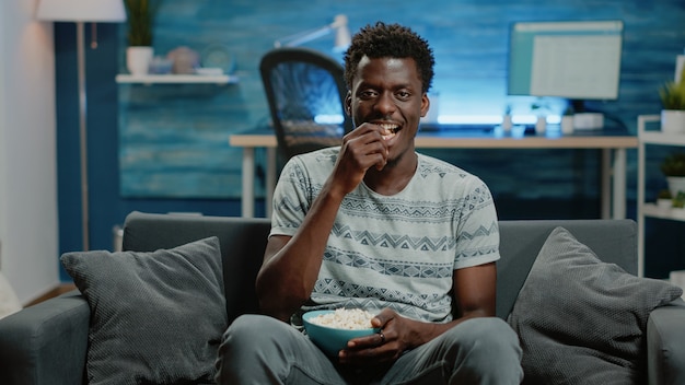 Pov de adultos viendo comedia en televisión con palomitas de maíz