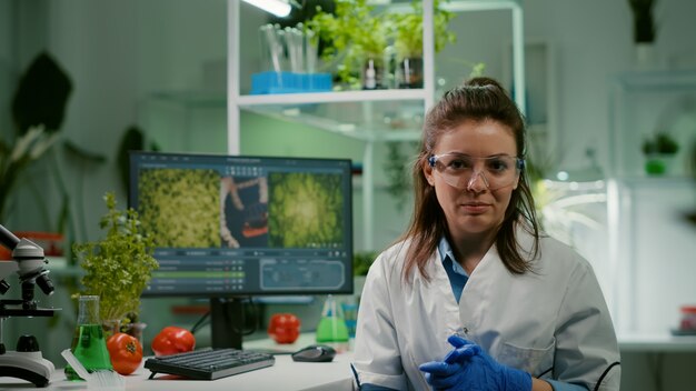 Pov de una mujer química con bata blanca analizando con el equipo de biólogos durante una videollamada en línea