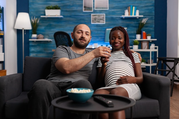 Pov de pareja interracial con embarazo viendo película