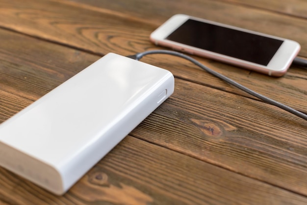 Foto gratuita powerbank y teléfono móvil en mesa de madera