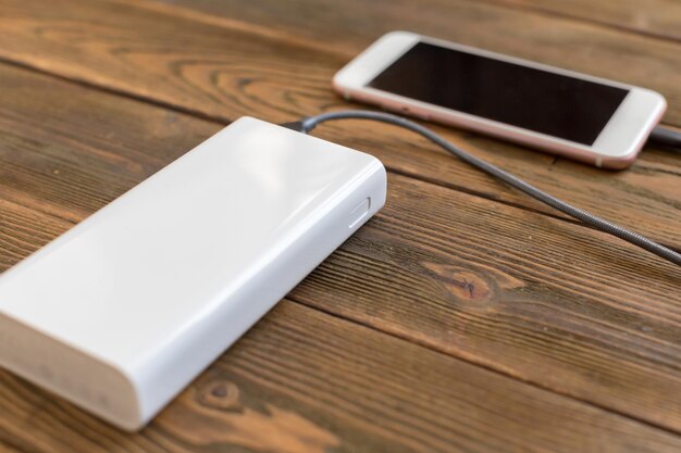 Powerbank y teléfono móvil en mesa de madera