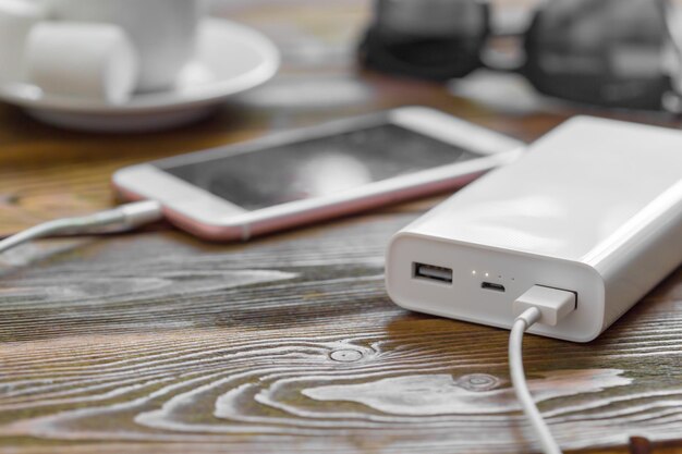 Powerbank y teléfono móvil en mesa de madera