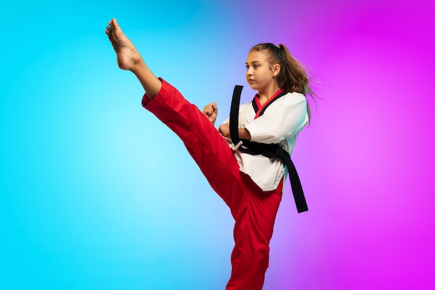 Práctica. Karate, taekwondo chica con cinturón negro aislado en gradiente