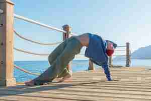 Foto gratuita práctica de yoga en el muelle